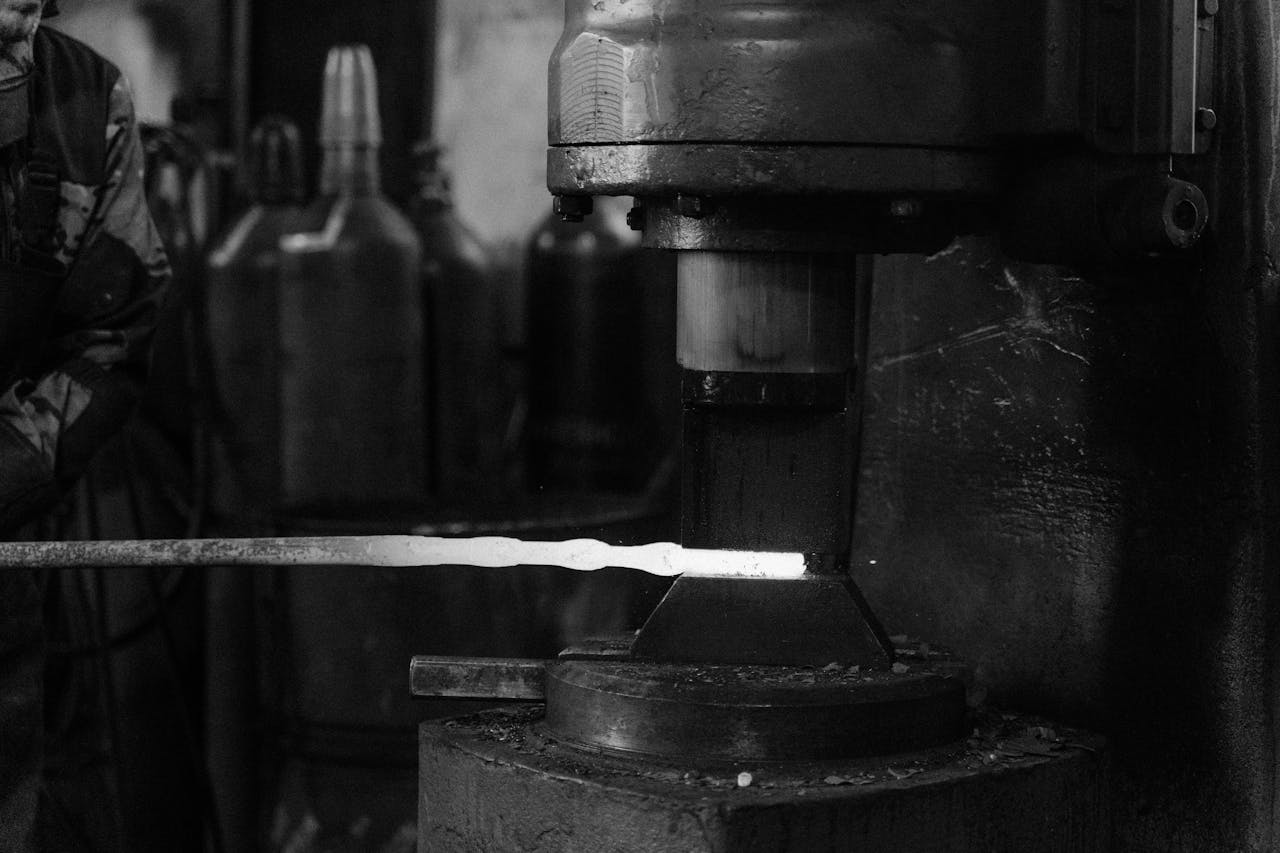 menu-02 Monochrome image of a blacksmith's forge with metal being processed.